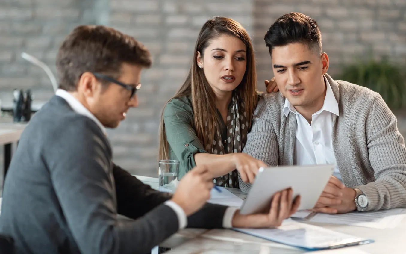 Young couple using touchpad with insurance agent